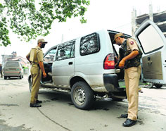 Securitymen search a taxi in Srinagar on Thursday.