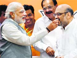 Amit Shah is offered sweets by PM Narendra Modi on his election as the BJP president in New Delhi on Wednesday