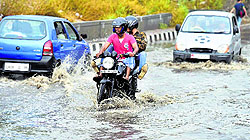 A biker wades through a water-logged street after rains in New Delhi on Sunday