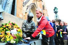 A woman lays flowers next to a wreath in memory of those killed in Malaysian Airlines crash, in Sydney on Saturday