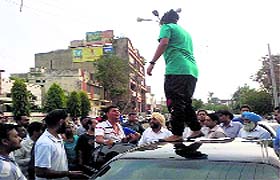 The infuriated girl climbs onto the youths' car at Mintgumri Chowk