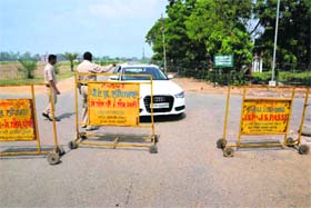 Security staff stop a car at a barricade set up on an internal road of the Punjab Agricultural University in Ludhiana