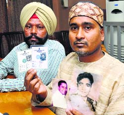 Dalip Jha (R), son of Ashutosh Maharaj, and Puran Singh, the preacher’s driver, with documents that support Dalip’s claims.