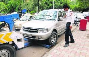 A wrongly parked vehicle being towed away by the traffic police from near the Bank Square in Sector 17, Chandigarh, on Monday.