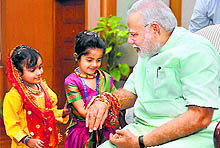 Children tie rakhi to Prime Minister Narendra Modi on the occasion of Raksha Bandhan in New Delhi on Sunday. Girls also tied rakhis to President Pranab Mukherjee and Union Home Minister Rajnath Singh in the Capital
