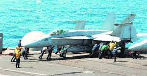 The US intervention in Iraq is a turning point in the conflict. The US Navy photograph shows sailors as they guide an F/A-18-C Hornet assigned to the Valions of Strike Fighter Squadron (VFA) on the flight deck of the aircraft carrier USS George HW Bush in the Gulf. Bush is supporting maritime security operations in the US 5th Fleet area of responsibility.