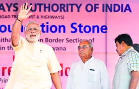PM Narendra Modi greets the crowd as CM Bhupinder Singh Hooda looks on in Kaithal
