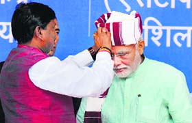 PM Narendra Modi is presented a turban by BJP leader Arjun Munda at a function in Ranchi on Thursday