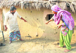 Residents of Jeora village show splinter marks on the wall of a house after Pakistan shelled Indian villages in RS Pura, Jammu.