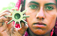 A woman holds a mortar shell.