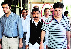 Sumit (left), Sunil and their father Ashanand (encircled), a former DSP with the Chandigarh Police, being produced in a court in Panchkula on Monday.