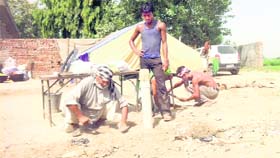 Workers install a tent at the venue for Chhapar Mela