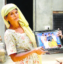 Santosh Rani of Jandu Singha village near Jalandhar shows the photograph of her son Amarjeet Singh stranded in Kuwait.