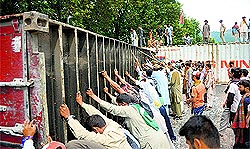 Imran Khan and Tahir ul-Qadris supporters try to remove a container near Parliament in Islamabad on Tuesday