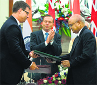 Indian and Australian officials exchange documents for the civil nuclear deal as Australian PM Tony Abbott looks on, in New Delhi on Friday.