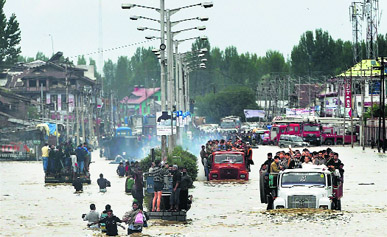 People being evacuated in trucks from flood-hit Batamaloo area of Srinagar on Sunday.