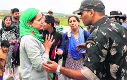 A woman pleads with an Army officer to rescue her family members in Srinagar on Monday. PTI