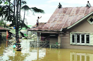 People wait for assistance on the roof of their house in Srinagar on Tuesday.