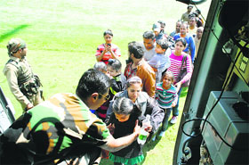 Armymen help tourists board an IAF helicopter after they were evacuated from a flooded area in Srinagar
