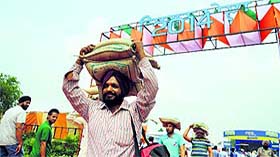 Visitors carry bags of seeds during the Kisan Mela
