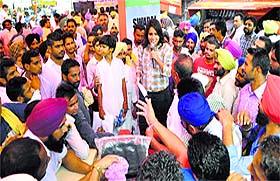 a woman representative of a tractor manufacturing company interacts with farmers during the Kisan Mela in Ludhiana on Friday.