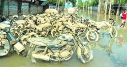 As floodwaters recede, motorcycles covered in mud are seen on a Srinagar street on Sunday.