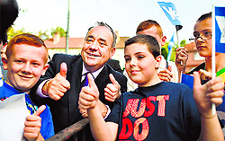 Scotlands First Minister Alex Salmond poses with children during a visit to a housing estate in Glasgow