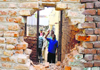 Villagers show a house damaged in shelling by the Pakistan Rangers in Arnia on Tuesday. Tribune Photo: Inderjeet Singh