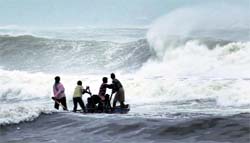 Fishermen battle rough waves in Visakhapatnam.