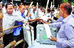 Poll officials wait to collect EVMs at a centre in Gurgaon on Tuesday