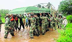Army personnel unload a boat for relief works at a village near Vizag on Tuesday