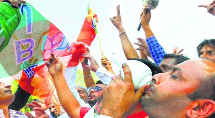 Blowing the trumpet: BJP supporters in Panchkula celebrate the sweeping victory of the party in Haryana on Sunday