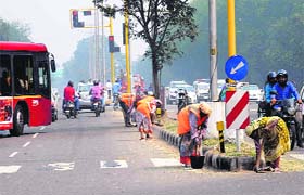 Smart act: PWD workers spruce up the road from The Tribune Chowk to the Transport Area lights ahead of Prime Minister Narendra Modi’s visit, in Chandigarh on Saturday