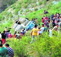 People gather near the ill-fated bus after the accident.