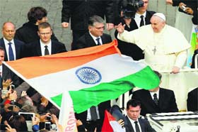 An Indian flag is waved near Pope Francis at the end of the canonisation mass in St Peter's Square, Vatican City, on Sunday