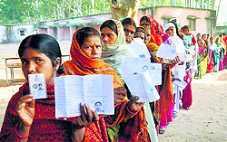 Women queue up to cast their vote at a polling booth during first phase of Assembly elections in Lohardaga district on Tuesday