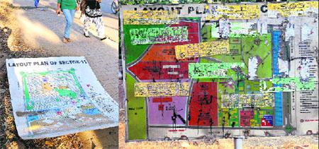 The layout plan of Sector 11 (left) lies on the pavement; and another defaced board at Sector 26 in Chandigarh on Wednesday