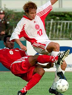 BANGKOK : Hong Kong's Kwok Yue Hung (right) is tackled by Oman player Fareed Ali Abdullah during their first round of the 13th Asian Games match at National Stadium in Bangkok on Monday. Oman leads 2-0 after first half. AP/PTI