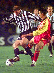 Juventus player Zinedine Zidane of France (left) is tackled by a Galatasaray player.