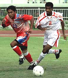 BANGKOK : Thailand's Tawan Sripan (left) fights for control of the ball with Oman's Mohamed Khamis during their first round 13th Asian Games soccer competition in Bangkok on Friday. Thailand won 2-0. AP/PTI