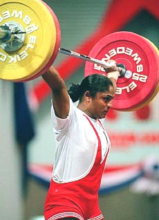 BANGKOK : India's Karnam Malleswari raises the bar over her head during the snatch competition in women's weightlifting at the 13th Asian Games in Bangkok on Thursday. She won the first medal for India, a silver, in the 63kg class competition with a total lift of 230 kg. AP/PTI
