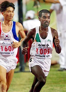 Gulab Chand of India (right) runs to the bronze medal during the men's 10,000-meter final in the 13th Asian Games in Bangkok on Sunday. At left is Baek Seung-Do of Korea. AP/PTI