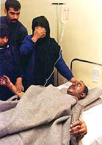 Grieving relatives at the bed of a man hospitalised in Baghdad.