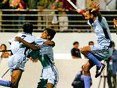 Indian players celebrate their victory over Korea in the men's field hockey final on Saturday at the 13th Asian Games. India beat Korea and won the gold medal after a tough match. — AFP photo.