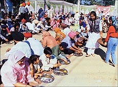 'Sangat' takes part in 'langar' at the Sector 34 Gurdwara in Chandigarh on Wednesday