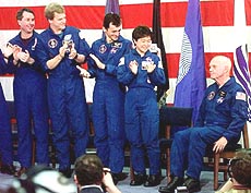 Space shuttle Discovery astronauts applaud their fellow crewmate, Sen. John Glenn.