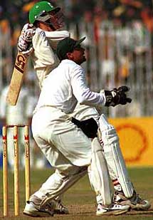 GUJRANWALA : Neil Johnson, Zimbabwe's opening batsman pulls Pakistan's off spinner Saqlain Mushtaq for a boundary while Moin Khan (front) Pakistan's wicketkeeper looks on at Jinnah stadium in Gujranwala on Friday.