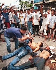 JAKARTA : Egged on by cheers from the crowd a man continues to strike three bodies of Ambonese men beaten and stabbed to death by an angry Muslim mob in Jakarta on Sunday. AP/PTI