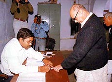 An election official putting the indelible mark on the finger of BJP president Kushabhau Thakre before he cast his vote at a polling booth in south Bhopal on Wednesday.
