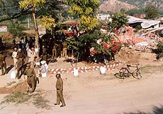 A strong posse of police personnel assisting the authorities during the demolition drive to thwart any untoward incidents. In the background pulled down structures can be noticed